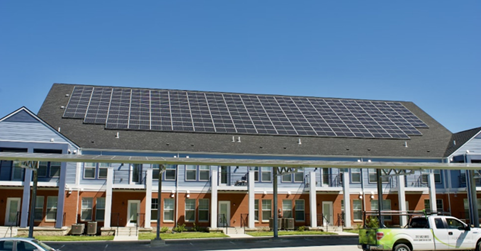 Image of rooftop solar panels on a multiunit housing development carport.